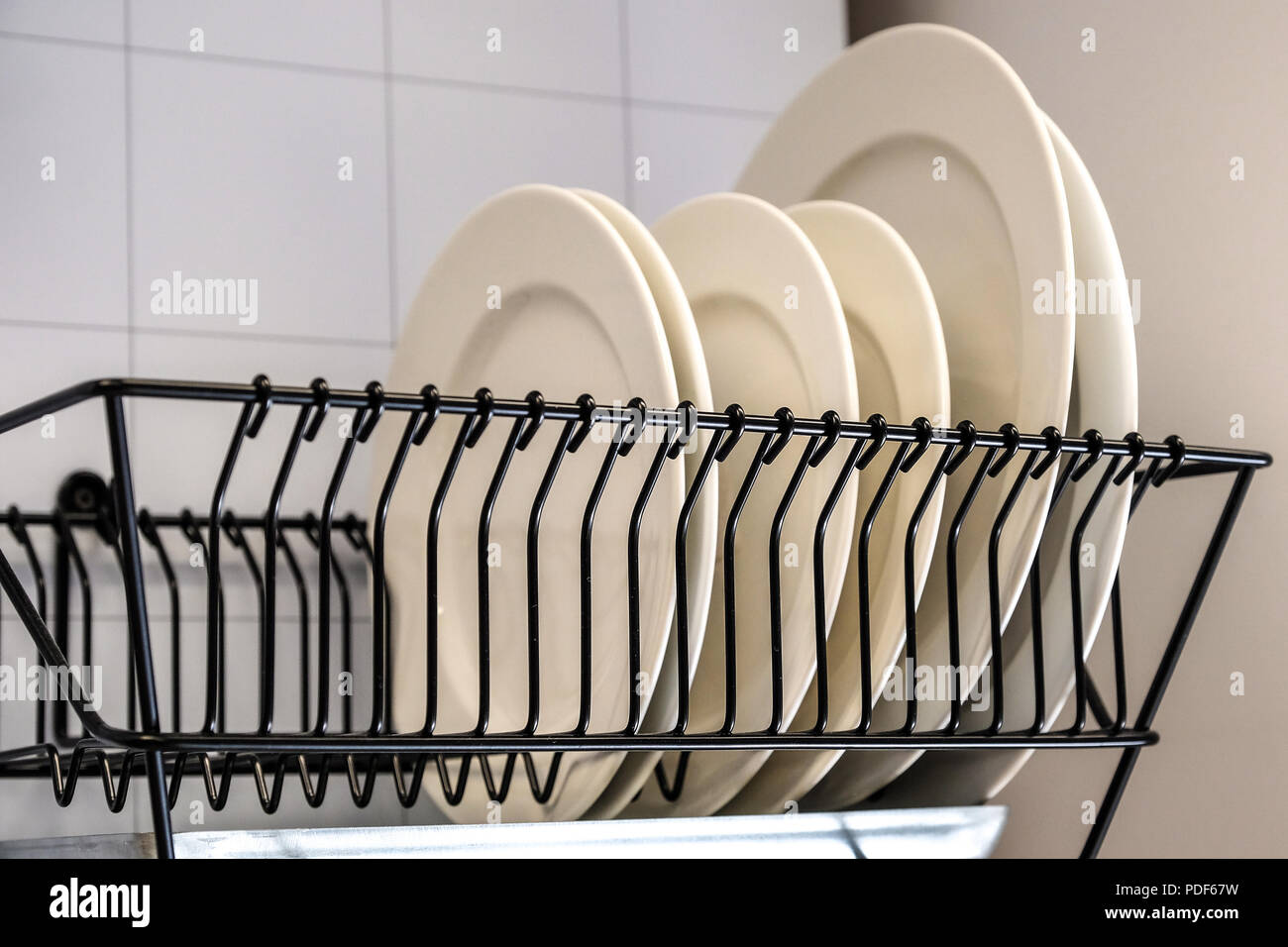 https://c8.alamy.com/comp/PDF67W/white-dishes-drying-on-metal-dish-rack-dish-drying-rack-the-dryer-is-fixed-horizontally-on-the-wall-PDF67W.jpg