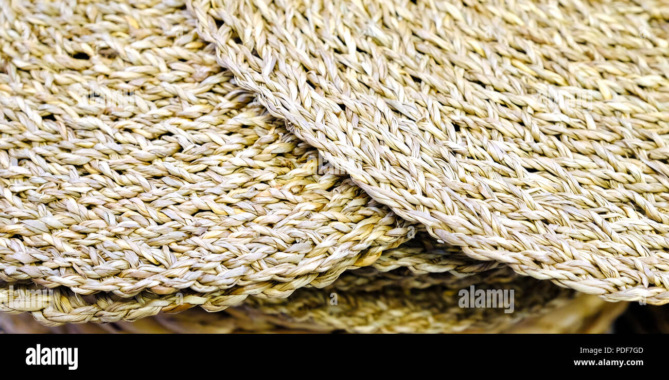 Woven circle Mat of reeds or strawyellow in color. The texture of dry