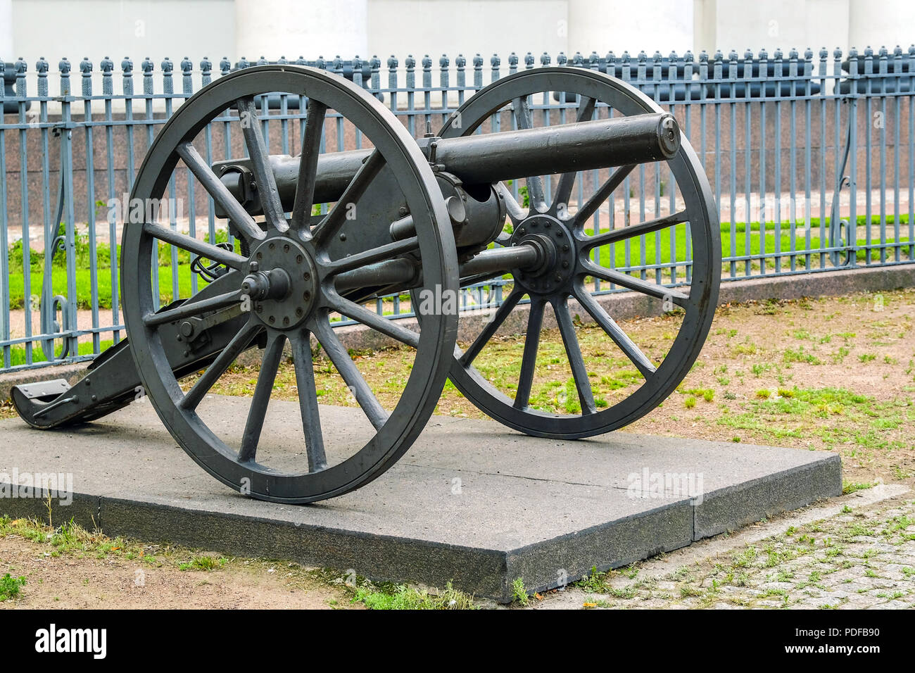 Vintage cast iron cannon on a carriage with large wheels. Against the fence  Stock Photo - Alamy