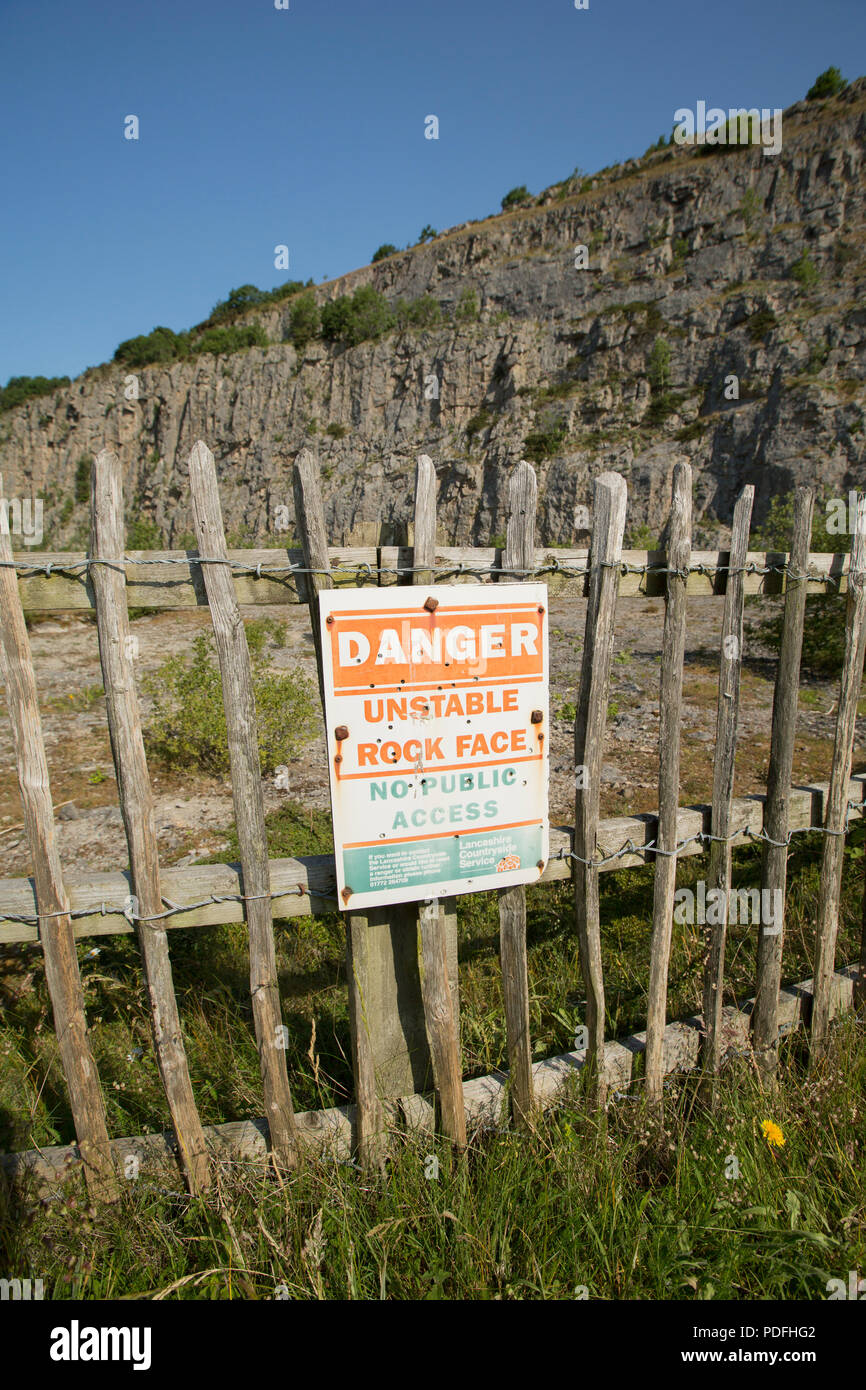 A warning sign in the entrance to a disused limestone quarry on Warton Crag in Lancashire England UK GB Stock Photo