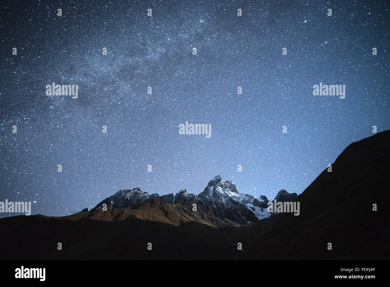 Night landscape. Starry sky with the Milky Way over the mountains ...