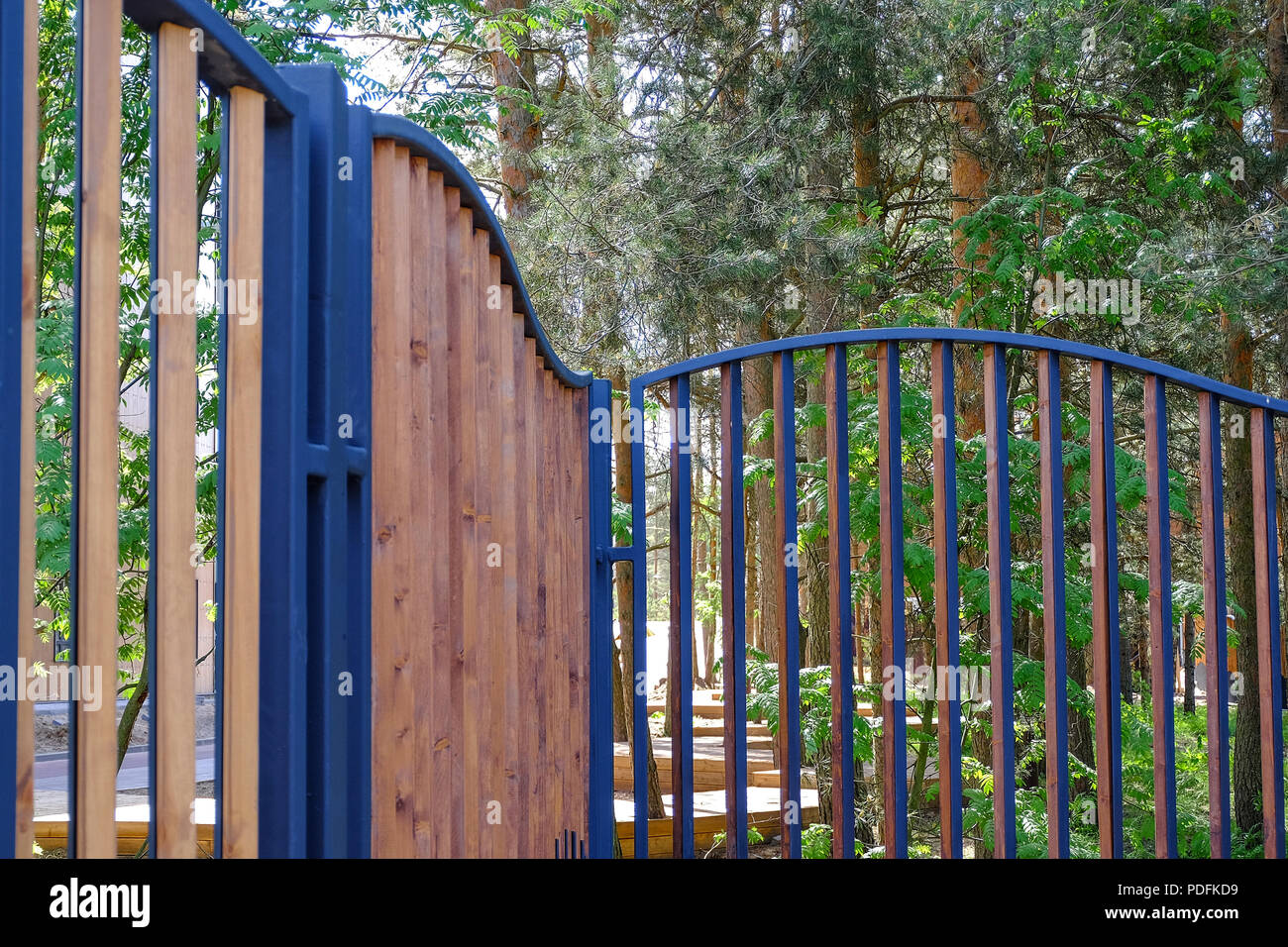 Wooden fence in a metal frame, the fence of the Park area. Stock Photo