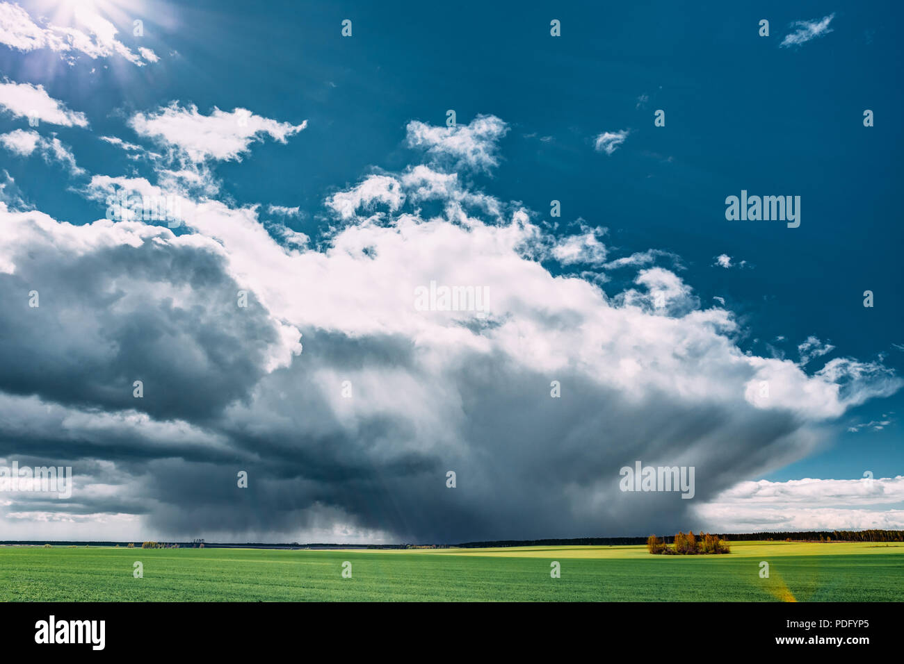 Coming Storm And Rain Above Countryside Rural Field Or Meadow Landscape With Green Grass Under Scenic Spring Blue Dramatic Sky With White Fluffy Cloud Stock Photo