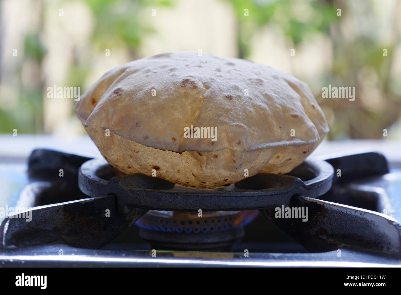 https://c8.alamy.com/comp/PDG11W/phulka-a-kind-of-chapati-home-made-indian-thin-bread-being-cooked-on-gas-stove-at-home-PDG11W.jpg