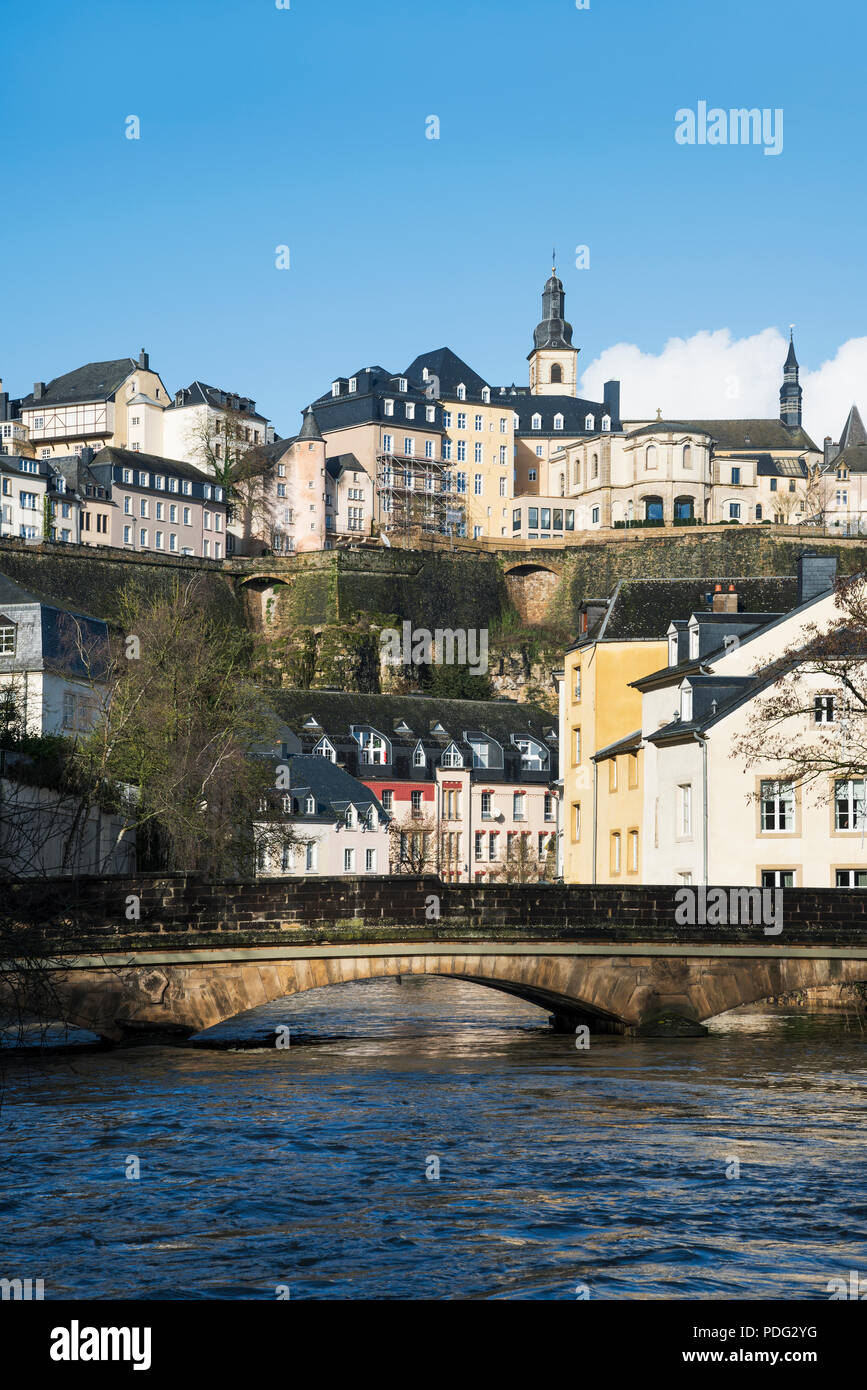a view of the Alzette River as it passes through the Grund Quarter in Luxembourg City, Luxembourg, and the Ville Haute Quarter on the top, highlightin Stock Photo