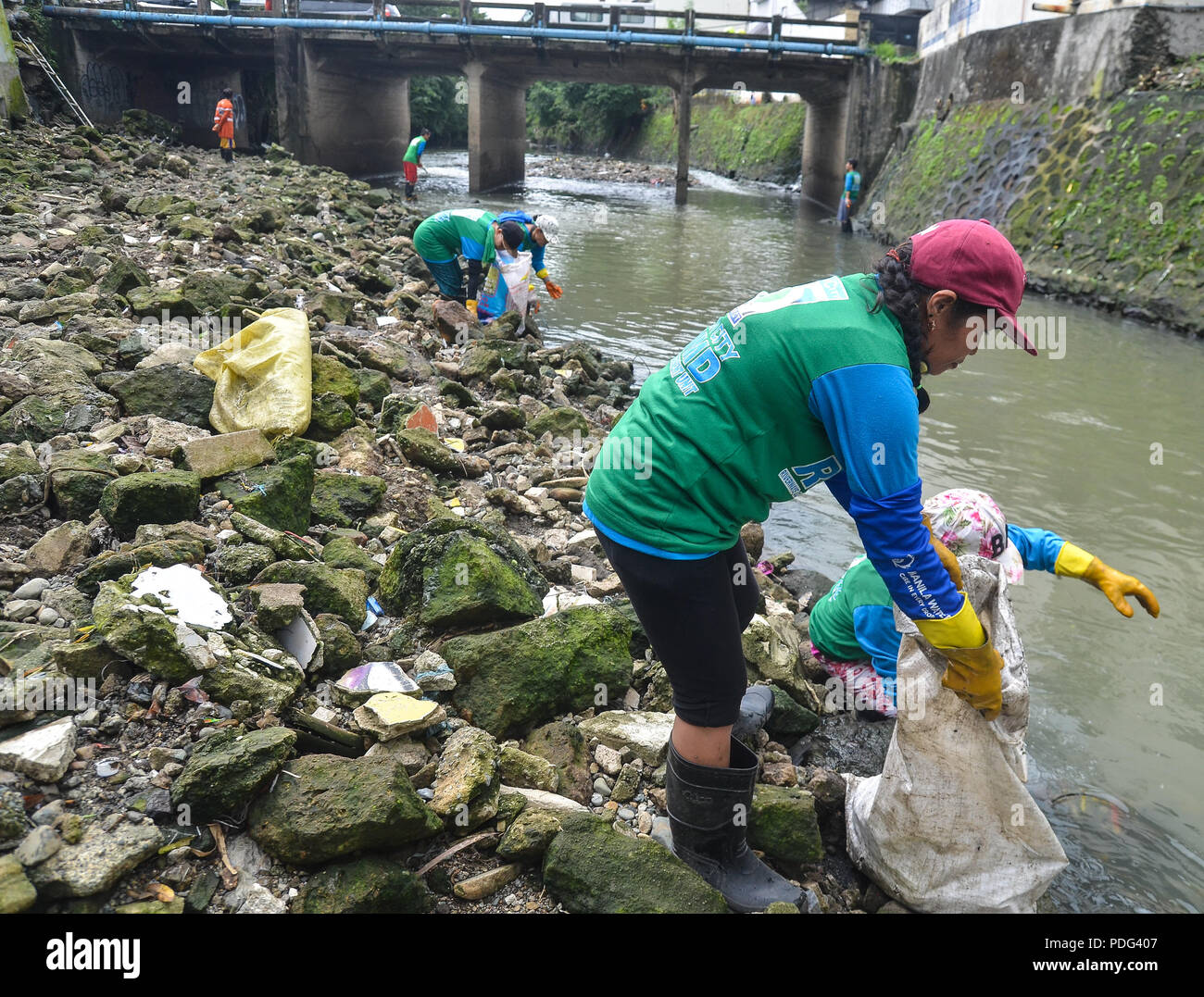 Quezon city Volunteers clean up and removing scattered waste under the ...