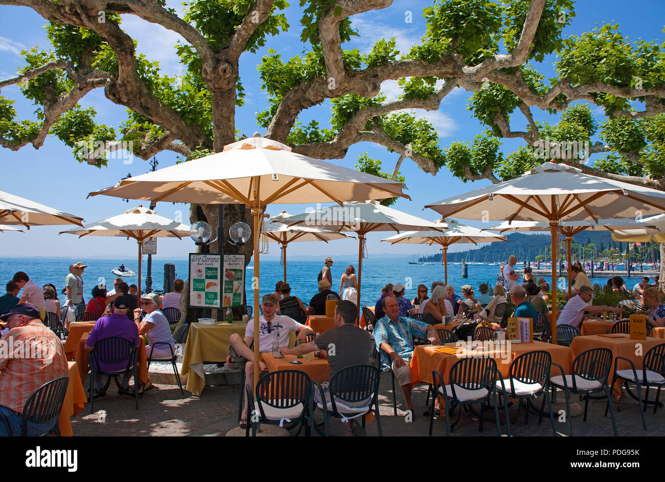 People in a Cafe at lake promenade, Garda, province Verona, Lake Garda, Italy Stock Photo