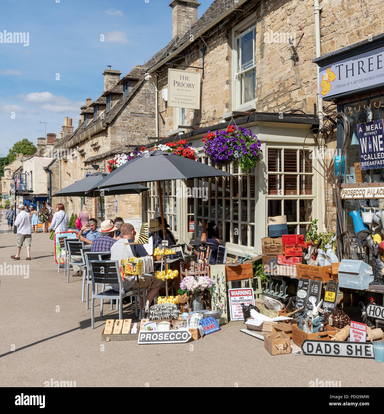 Burford, Oxfordshire, England, UK. Tourists enjoying the town centre activities,cafe, restaurant, shopping. Stock Photo