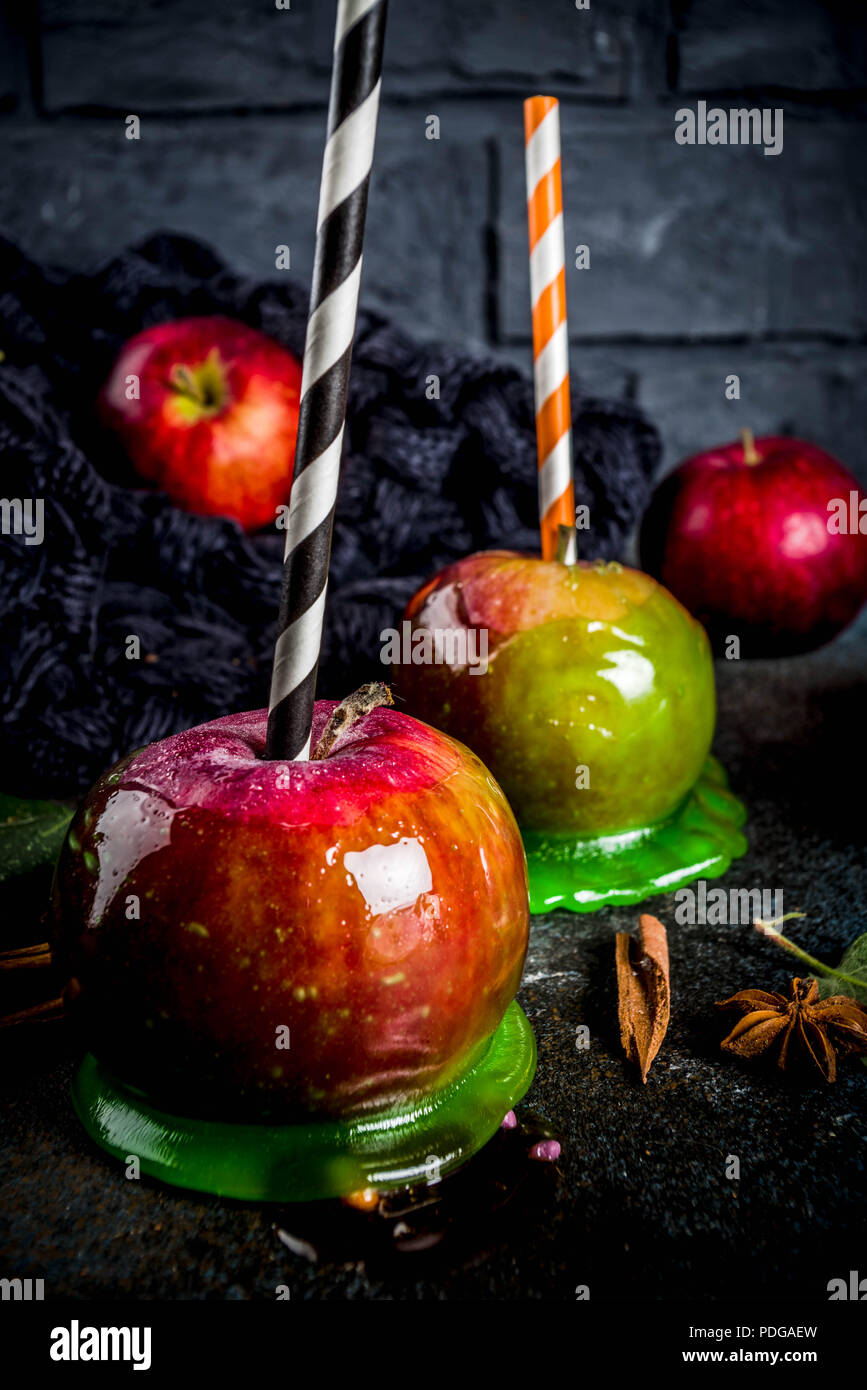 Traditional autumn delicacy, apples in caramel glaze. On a dark