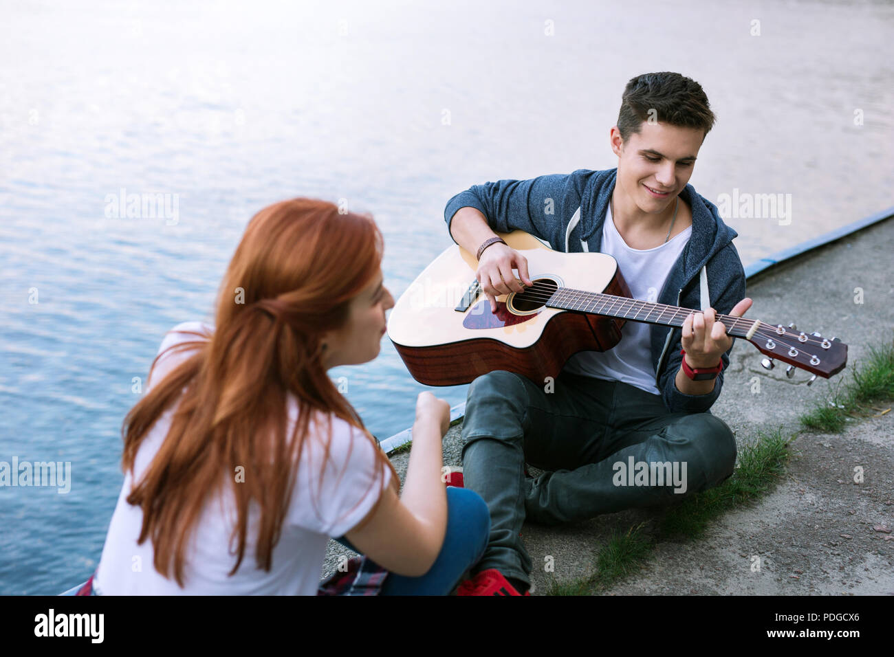 Positive joyful man playing the guitar Romantic date. Stock Photo