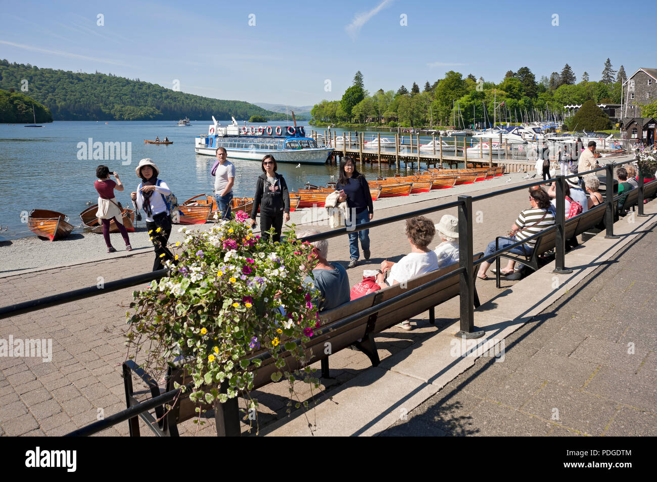 People tourists visitors by the lake in summer Bowness on Windermere Lake District National Park Cumbria England UK United Kingdom GB Great Britain Stock Photo