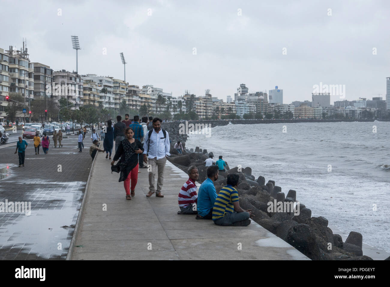 People on Marine Drive promenade during monsoon season in Mumbai, India