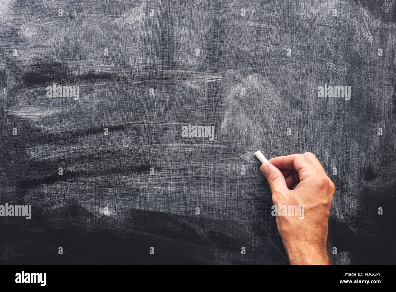 Teacher's hand is writing with chalk on blackboard, blank mock up copy space Stock Photo