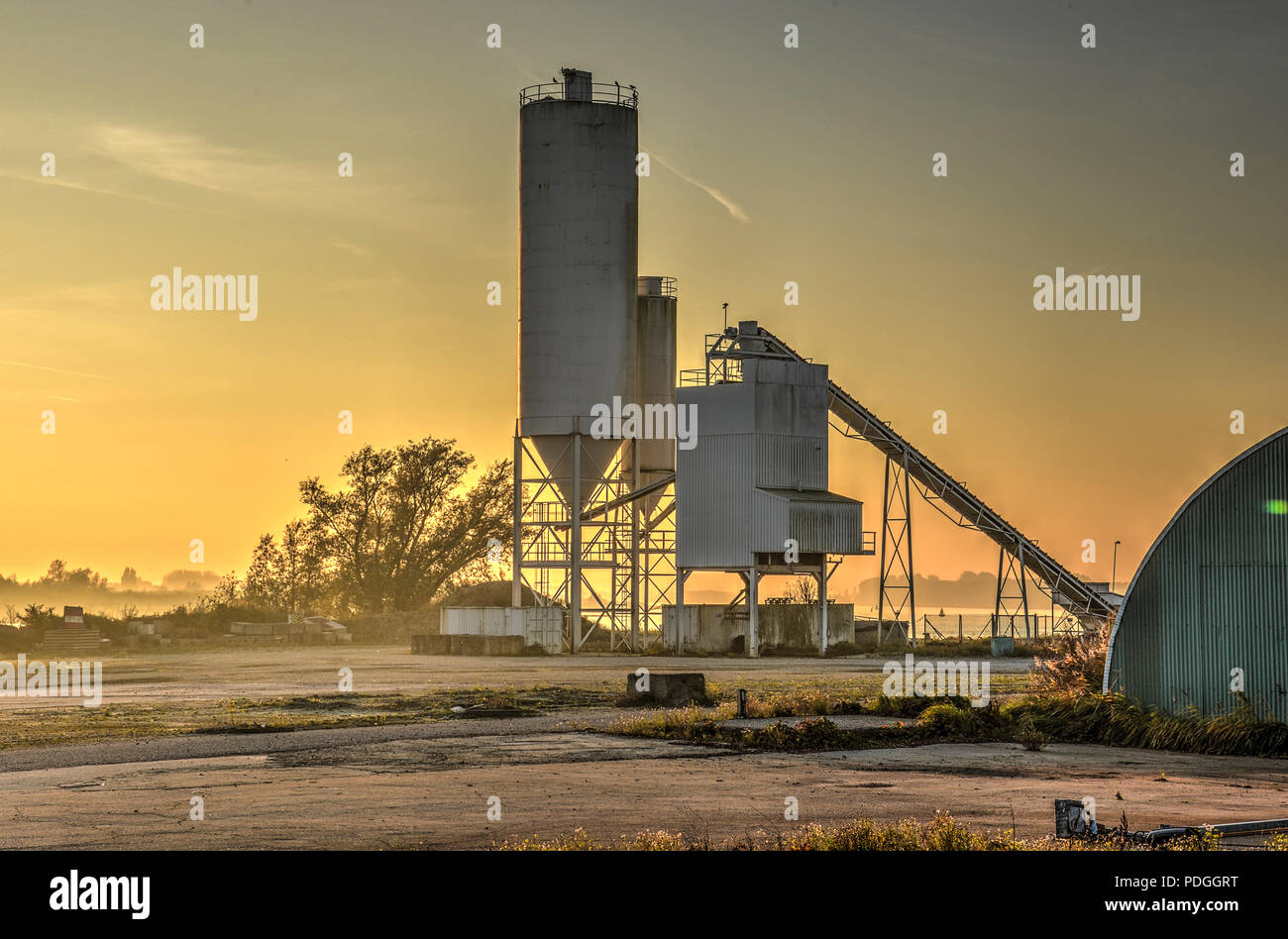 Barendrecht, The Netherlands, November 1, 2015: Small grainsilo at the bank of the Oude Maas river at sunset Stock Photo