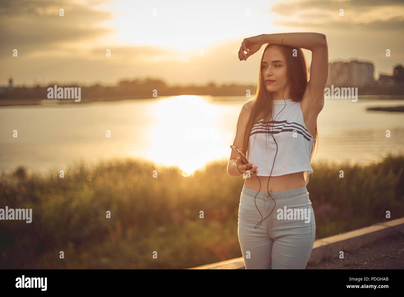 Young beautiful caucasian girl listening to music with smartphone walking in the city with headphones smiling - relax, youth, emancipation concept Stock Photo