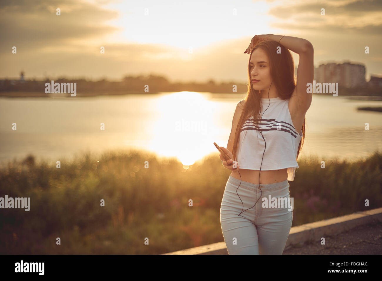 Young beautiful caucasian girl listening to music with smartphone walking in the city with headphones smiling - relax, youth, emancipation concept Stock Photo