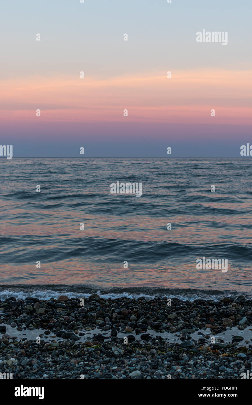 Waves gently lapping a peeble shore at dusk, Murlough Beach, Newcastle, County Down, Stock Photo