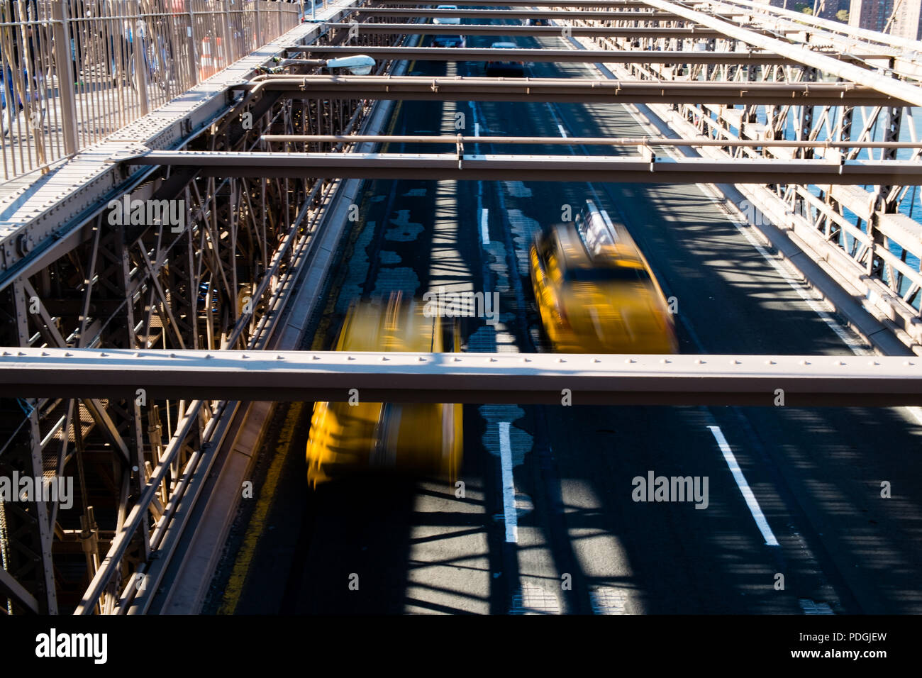 Yellow taxis speeding over Brooklyn Bridge Stock Photo