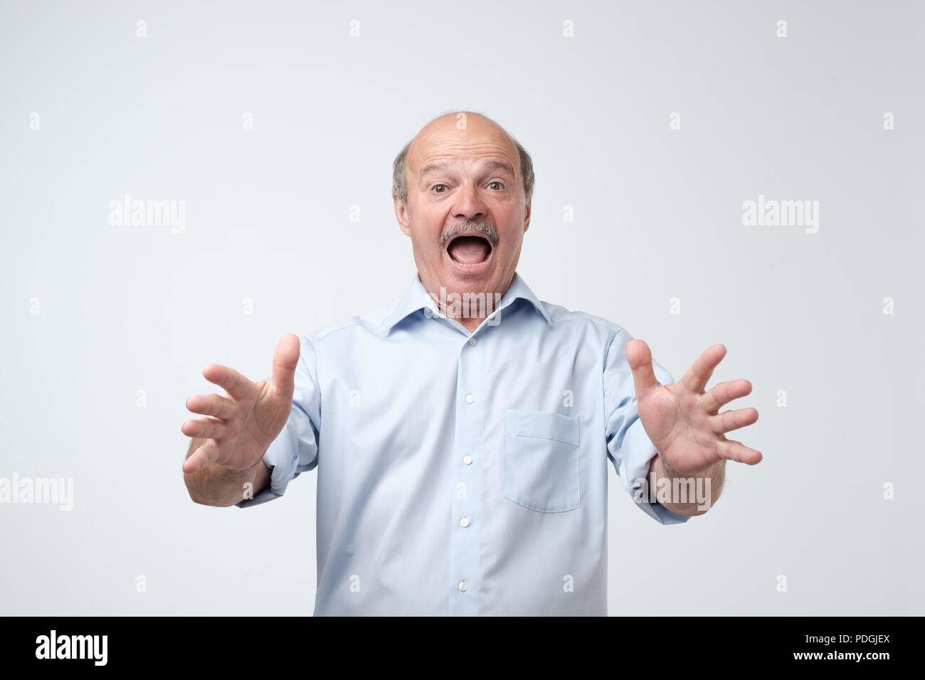 Studio shot of mature hispanic man against gray background. I can not belive what are you saying. Stock Photo