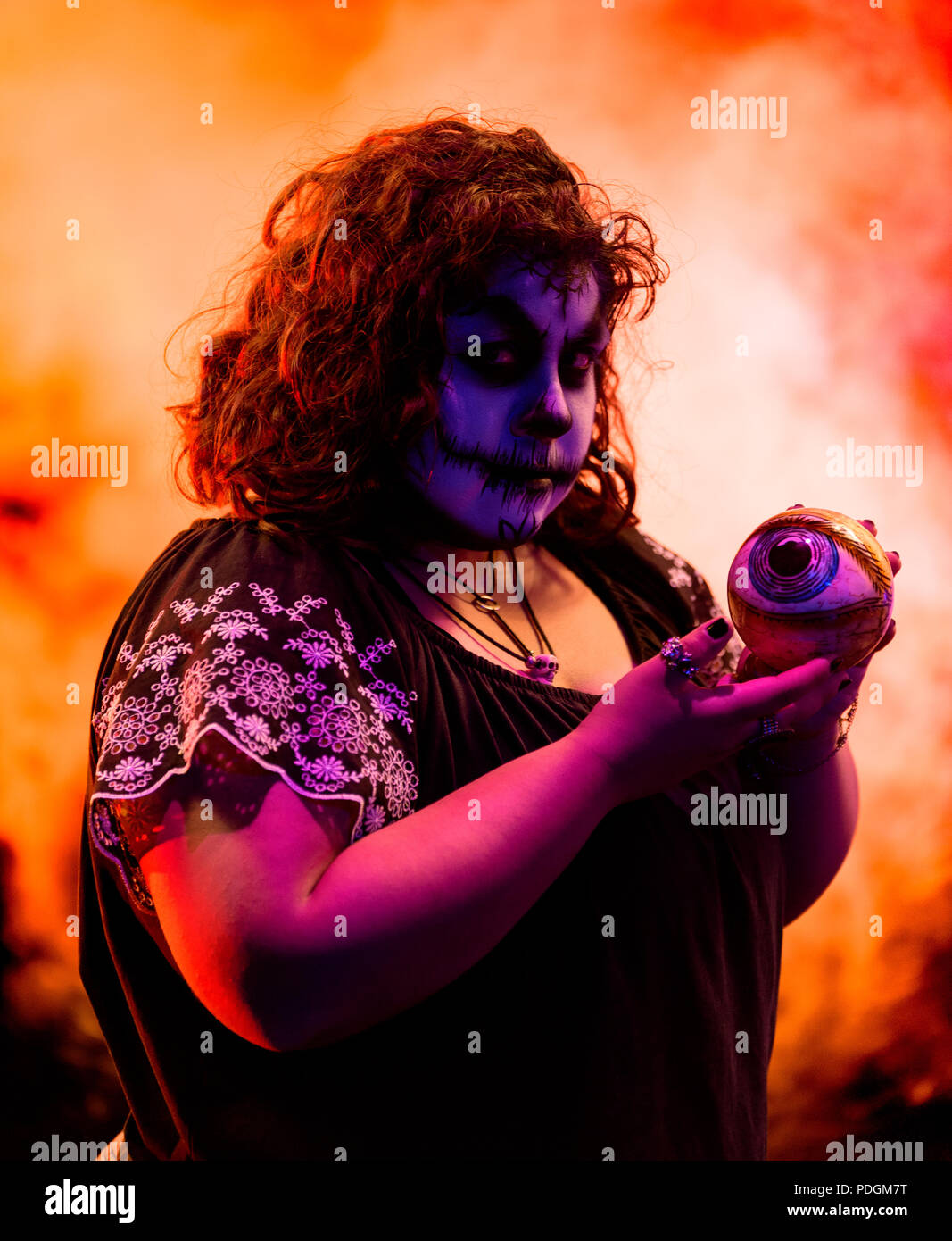 A latina female model with a more horror and halloween style approach to Day of the Dead makeup. Shot against a black background with theatrical light Stock Photo