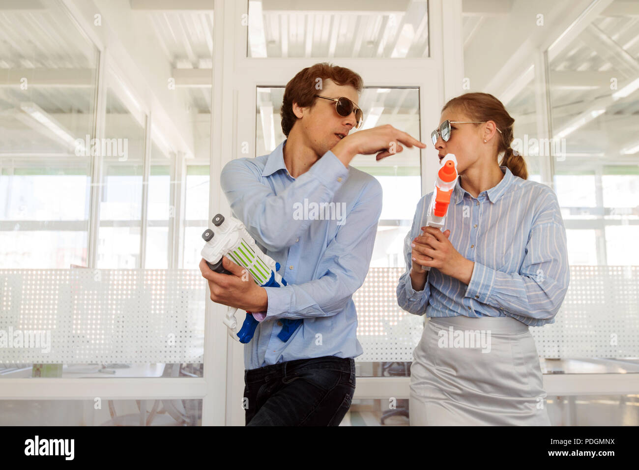 Playful colleagues with toy guns Stock Photo