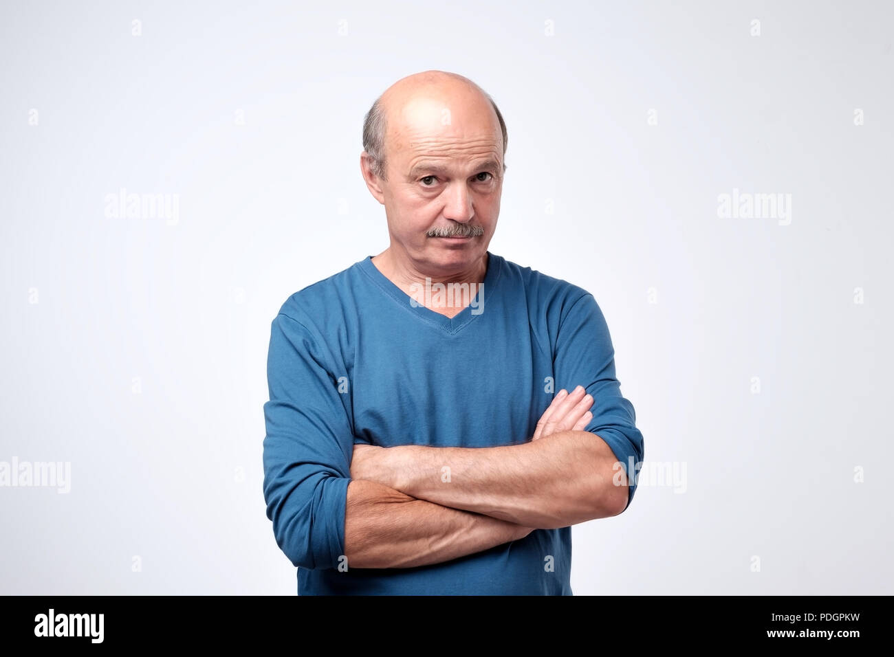 Portrait of mature confident serious guy with crossed hands. Stock Photo