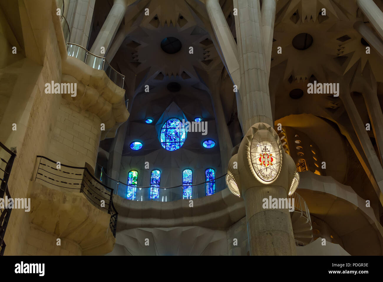 Architectural details of blue stained glass window and Barcelona lamp on column inside Sagrada Familia - large unfinished Roman Catholic church in Bar Stock Photo