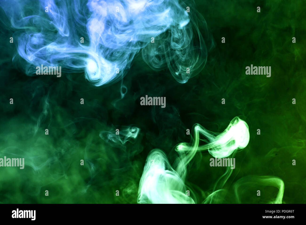 Colorful blue and green smoke on a black isolated background ...
