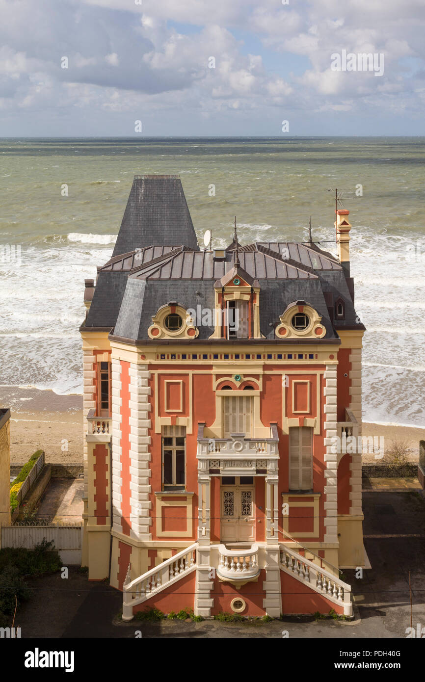 The 'Villa des Flots', a Belle Epoque house on the beach at Trouville-sur-Mer, Normandy, France with rough seas behind Stock Photo