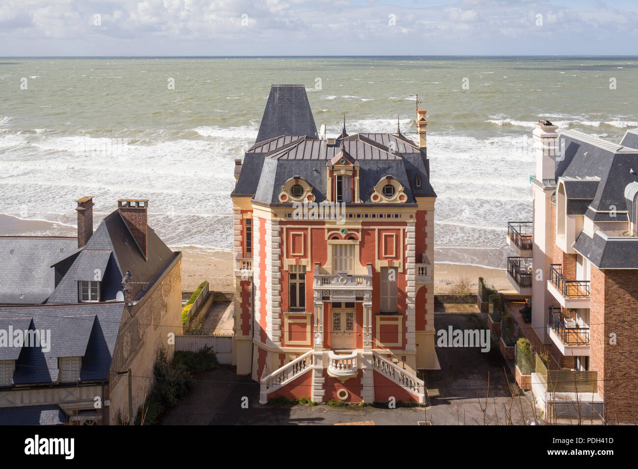 The 'Villa des Flots', a Belle Epoque house on the beach at Trouville-sur-Mer, Normandy, France with rough seas behind Stock Photo