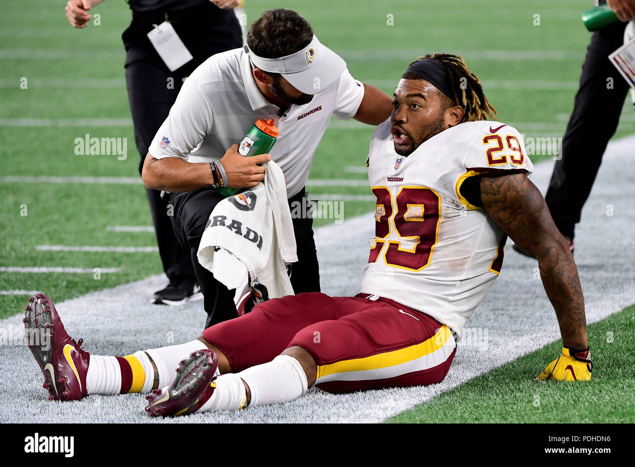 Foxborough, USA. August 9, 2018: Washington Redskins running back Derrius Guice (29) gets attention from training staff after being tackled during the NFL pre-season football game between the Washington Redskins and the New England Patriots at Gillette Stadium, in Foxborough, Massachusetts. The Patriots defeat the Redskins 26-17. Eric Canha/CSM Stock Photo