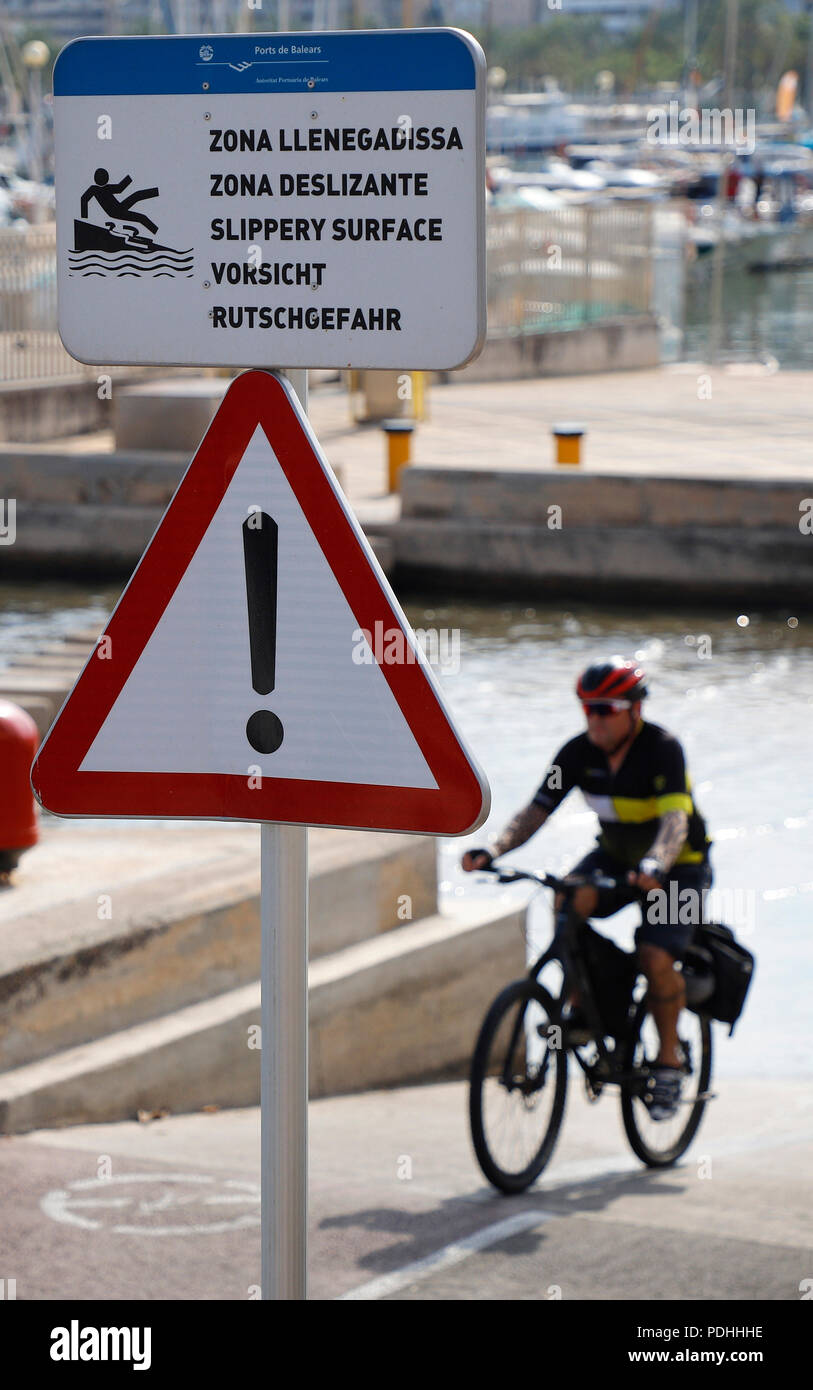 Palma de Mallorca, Spain. 09th Aug, 2018. A traffic sign 'Gefahrenstelle' and a lettering in Catalan, Spanish, English and German point out the danger of slipping at the port of Palma. Credit: Clara Margais/dpa/Alamy Live News Stock Photo
