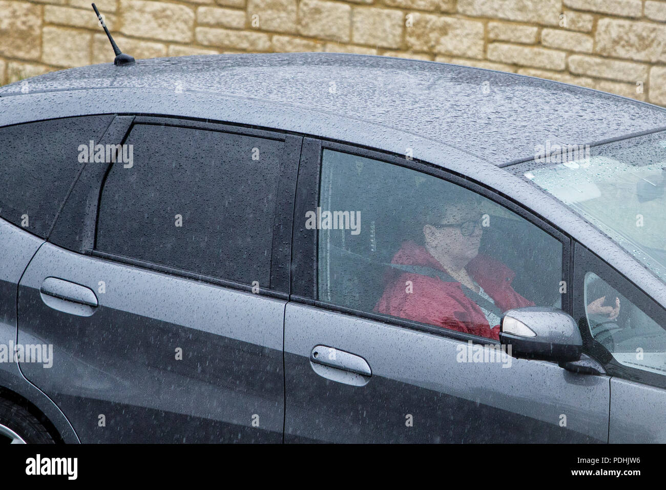 Chippenham, UK, 10th August, 2018. Car drivers are pictured sitting in traffic in Chippenham as heavy rain showers make their way across Southern England. Credit: Lynchpics/Alamy Live News Stock Photo