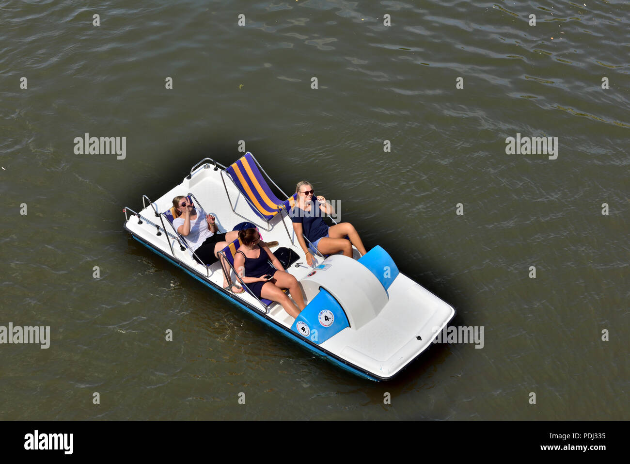 Three women in a pedalo boat on river Vitava in central Prague, Czech