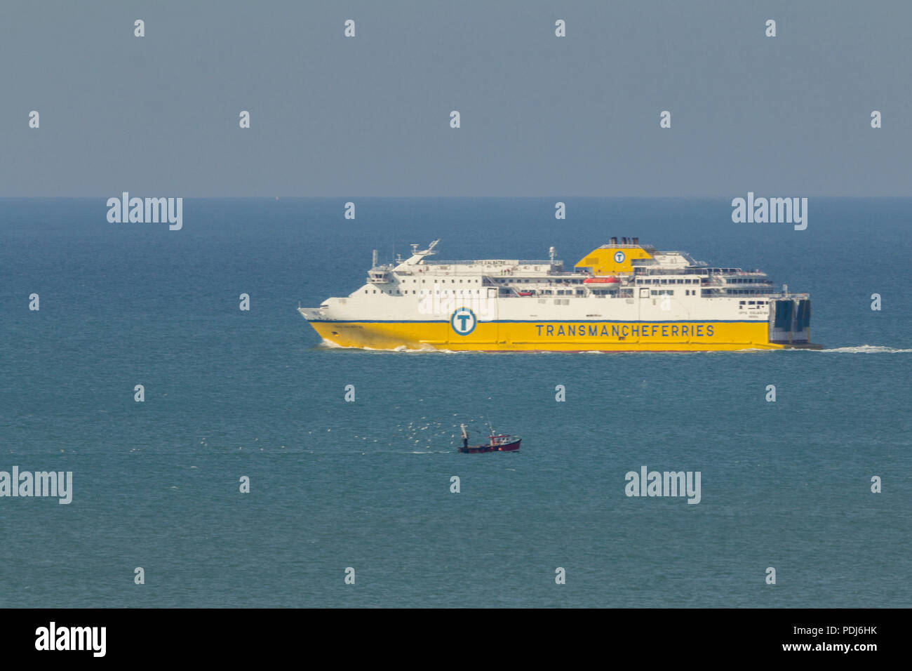 Ferry and a fishing boat at sea showing size difference between the two