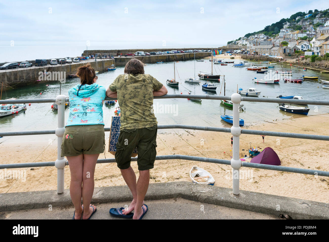 Holidaymakers enjoying the view of Mousehole Harbour in Cornwall. Stock Photo