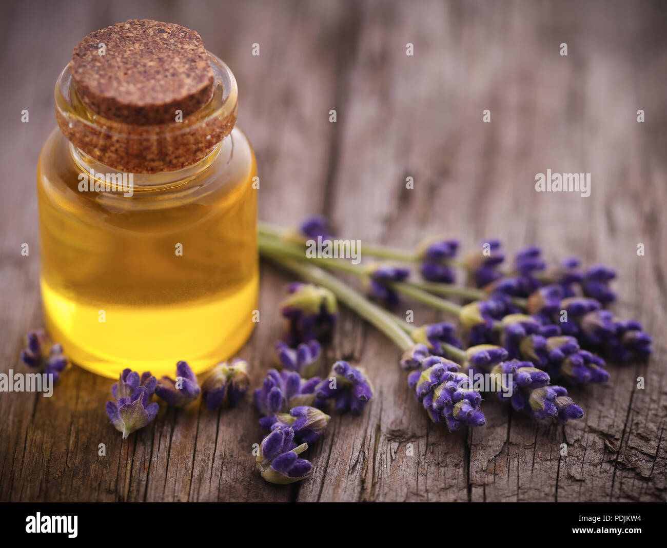 Lavender oil with flower on wooden surface Stock Photo