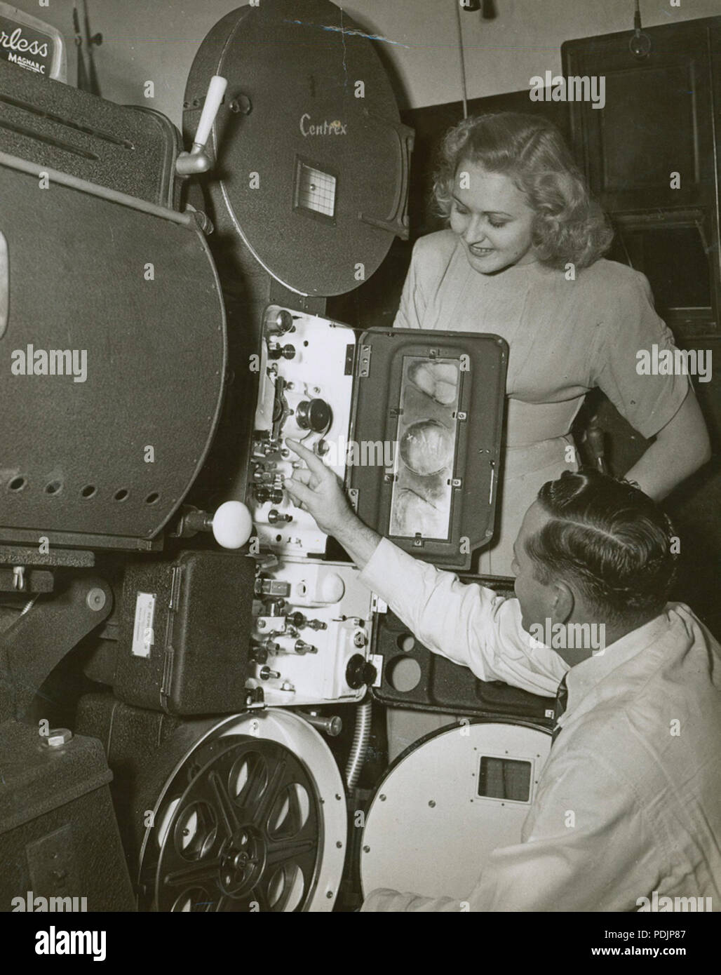 123 R.J. (Bob) Lucas and unidentified woman looking at a Centrex projector, 1940 - 1949 (4436758030) Stock Photo