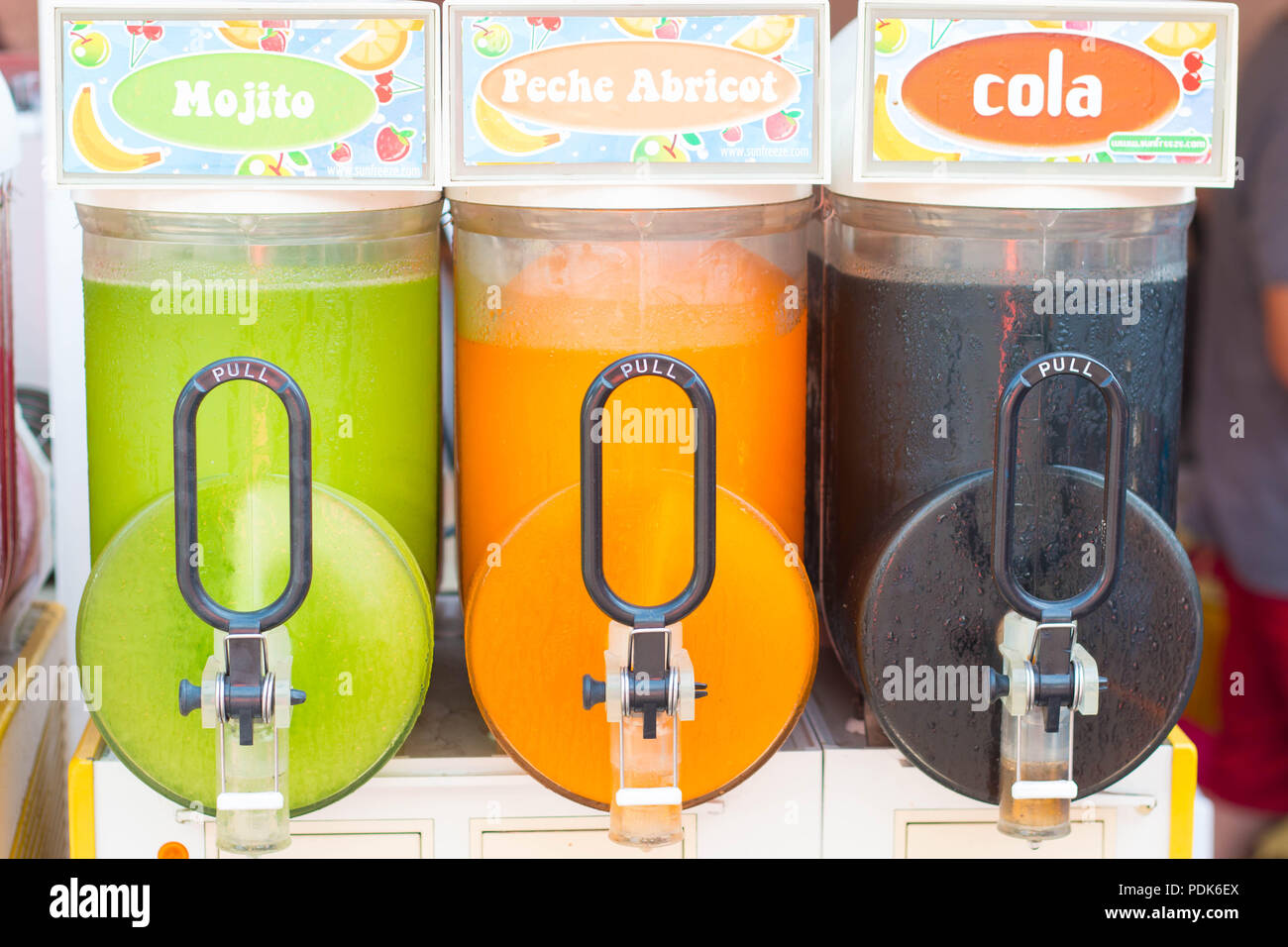 three Colorful slush dispensers close up with 'pull' written on the lever Stock Photo