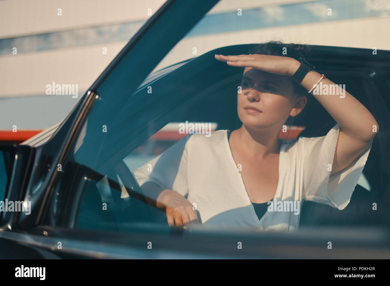 Woman getting down from car searching with eyes for somebody Stock Photo