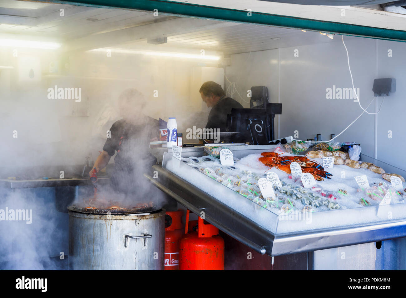 Stall steaming crabs and selling fresh seafood on display in Littlehampton, a small holiday resort on the south coast in West Sussex, UK in summer Stock Photo