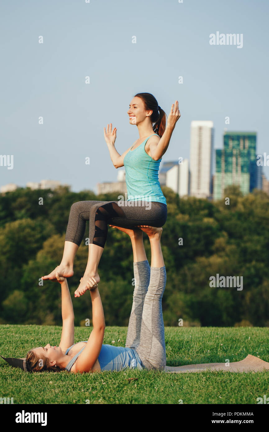 Fit young couple doing acro yoga at spa retreat on sea beach. Active woman  balancing on partner feet, stretching at acroyoga pose. Healthy lifestyle  Stock Photo - Alamy