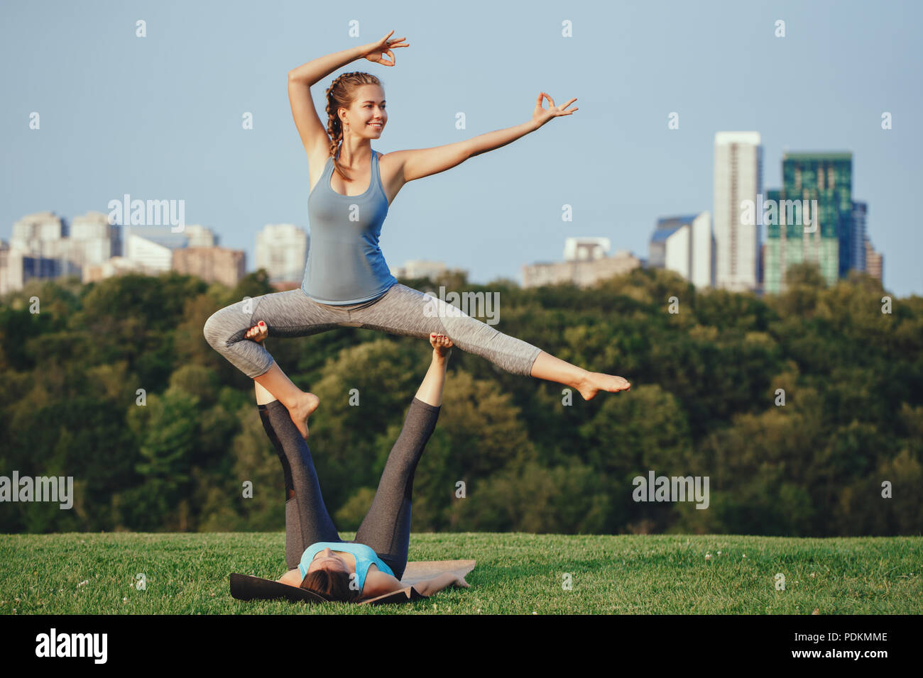 Two young beautiful Caucasian women yogi doing ninja acro yoga pose ...