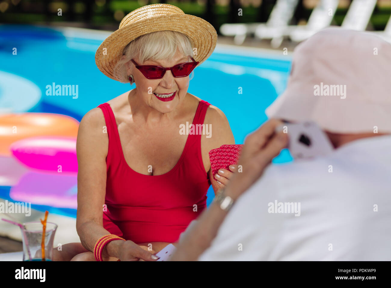 Blonde-haired fashionable woman wearing bright red sunglasses Stock Photo