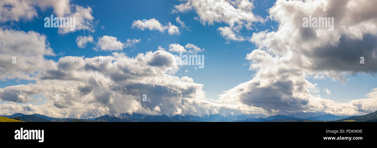 panorama of a gorgeous cloudscape above the mountain ridge. beautiful ...