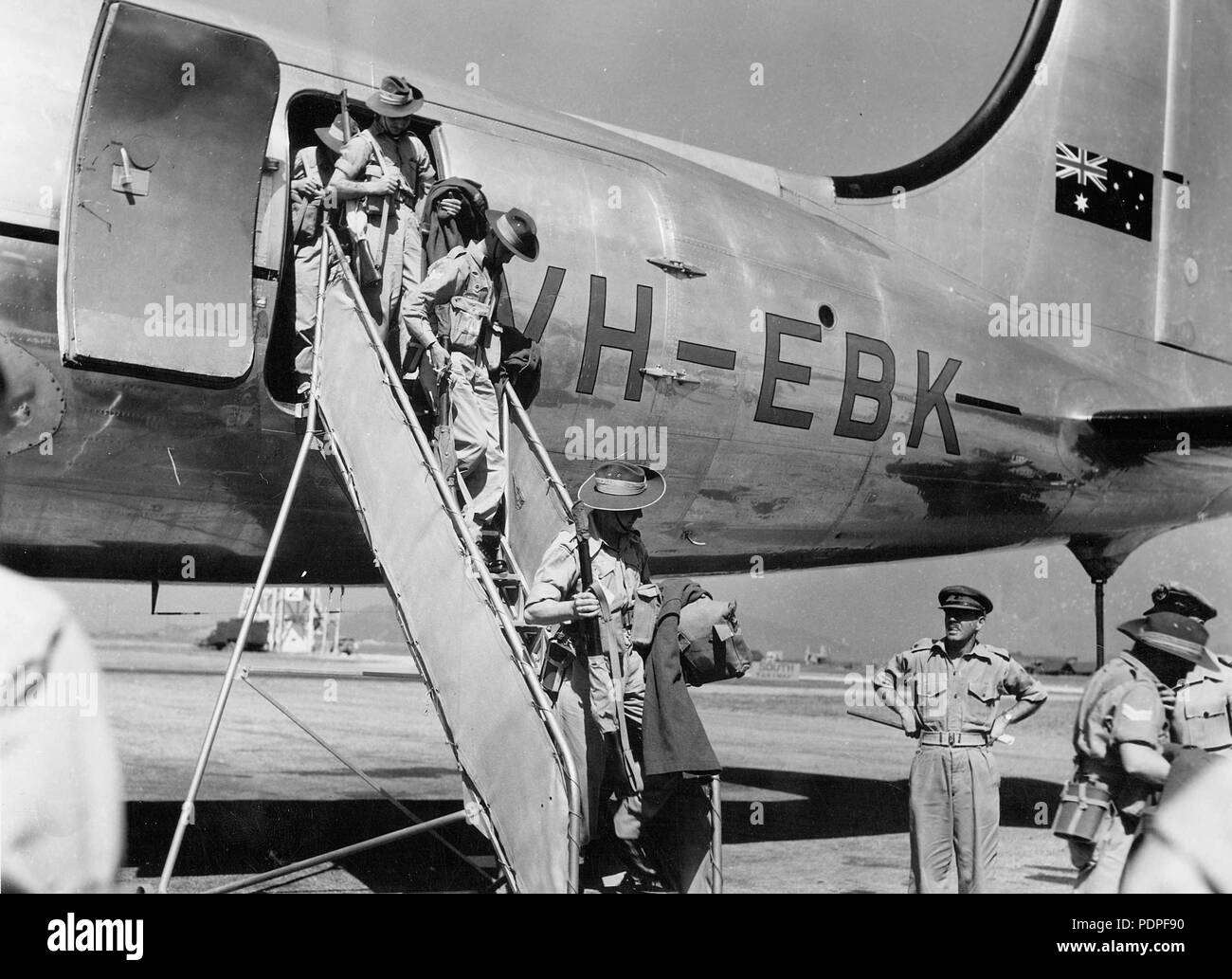 18 Australian soldiers deplane a Qantas Empire Airways Douglas DC-4 (VH-EBK) Stock Photo