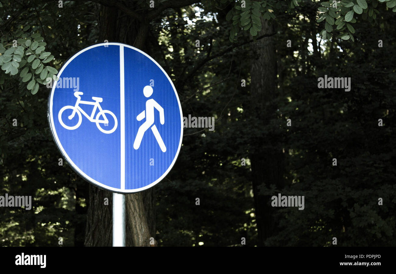 Blue bicycle and walk lane sign with trees background Stock Photo Alamy