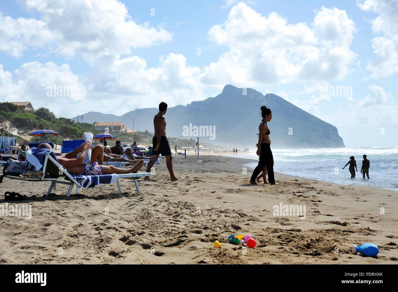 Relaxed people on the Sabaudia beach for the summer holidays. The Circeo Mountain on the background. Sabaudia, Lazio, Italy. Stock Photo