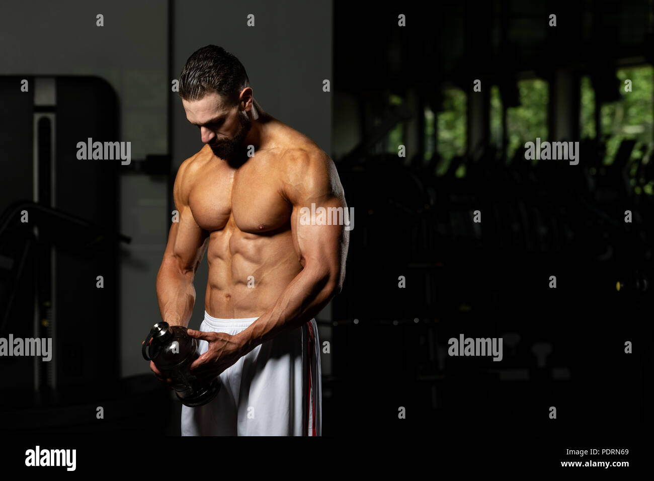 Muscular Man Resting After Exercise And Drinking From Shaker Stock Photo -  Alamy
