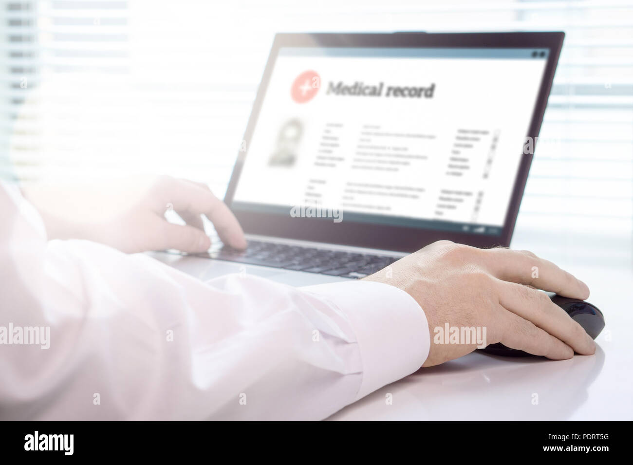 Doctor using laptop and electronic medical record (EMR) system. Digital database of patient's health care and personal information on computer screen. Stock Photo